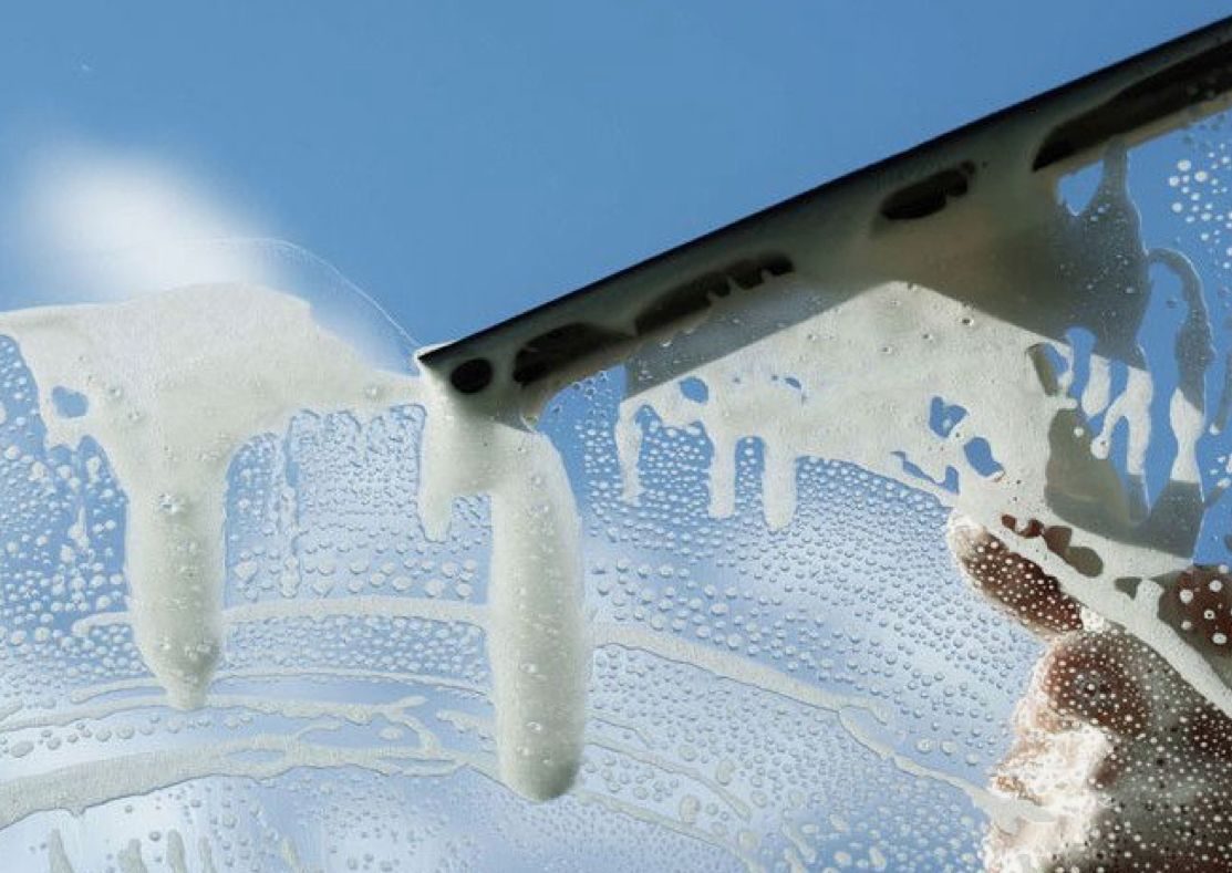 Fensterreinigung in Nürnberg – Glasscheibe wird mit Abzieher und Reinigungsschaum streifenfrei gereinigt.
