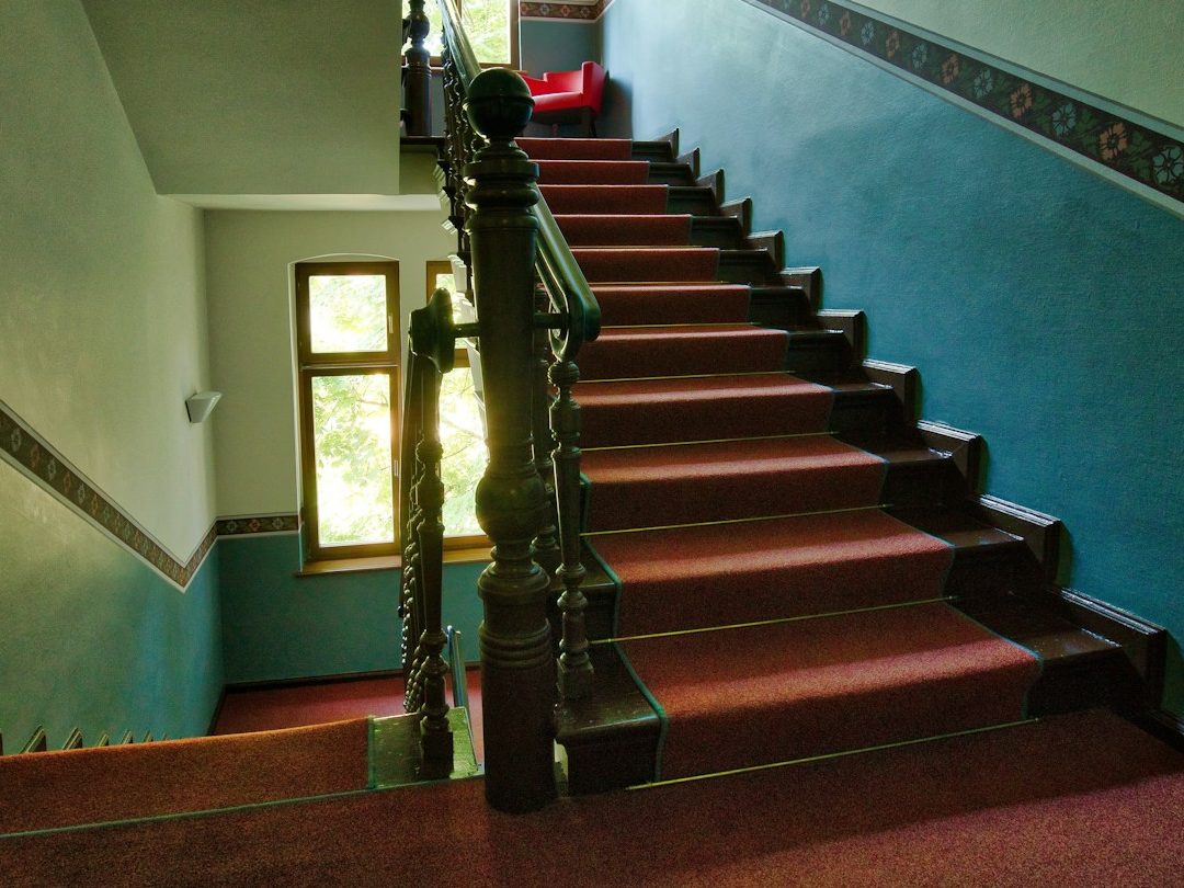 Treppenhausreinigung in Nürnberg – Blick in ein mehrstöckiges Treppenhaus mit Teppichstufen.